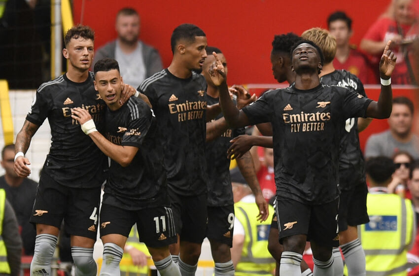 Arsenal's English midfielder Bukayo Saka (R) celebrates with teammates after scoring their first goal during the English Premier League football match between Manchester United and Arsenal at Old Trafford in Manchester, north west England, on September 4, 2022. - RESTRICTED TO EDITORIAL USE. No use with unauthorized audio, video, data, fixture lists, club/league logos or 'live' services. Online in-match use limited to 120 images. An additional 40 images may be used in extra time. No video emulation. Social media in-match use limited to 120 images. An additional 40 images may be used in extra time. No use in betting publications, games or single club/league/player publications. (Photo by Oli SCARFF / AFP) / RESTRICTED TO EDITORIAL USE. No use with unauthorized audio, video, data, fixture lists, club/league logos or 'live' services. Online in-match use limited to 120 images. An additional 40 images may be used in extra time. No video emulation. Social media in-match use limited to 120 images. An additional 40 images may be used in extra time. No use in betting publications, games or single club/league/player publications. / RESTRICTED TO EDITORIAL USE. No use with unauthorized audio, video, data, fixture lists, club/league logos or 'live' services. Online in-match use limited to 120 images. An additional 40 images may be used in extra time. No video emulation. Social media in-match use limited to 120 images. An additional 40 images may be used in extra time. No use in betting publications, games or single club/league/player publications. (Photo by OLI SCARFF/AFP via Getty Images)